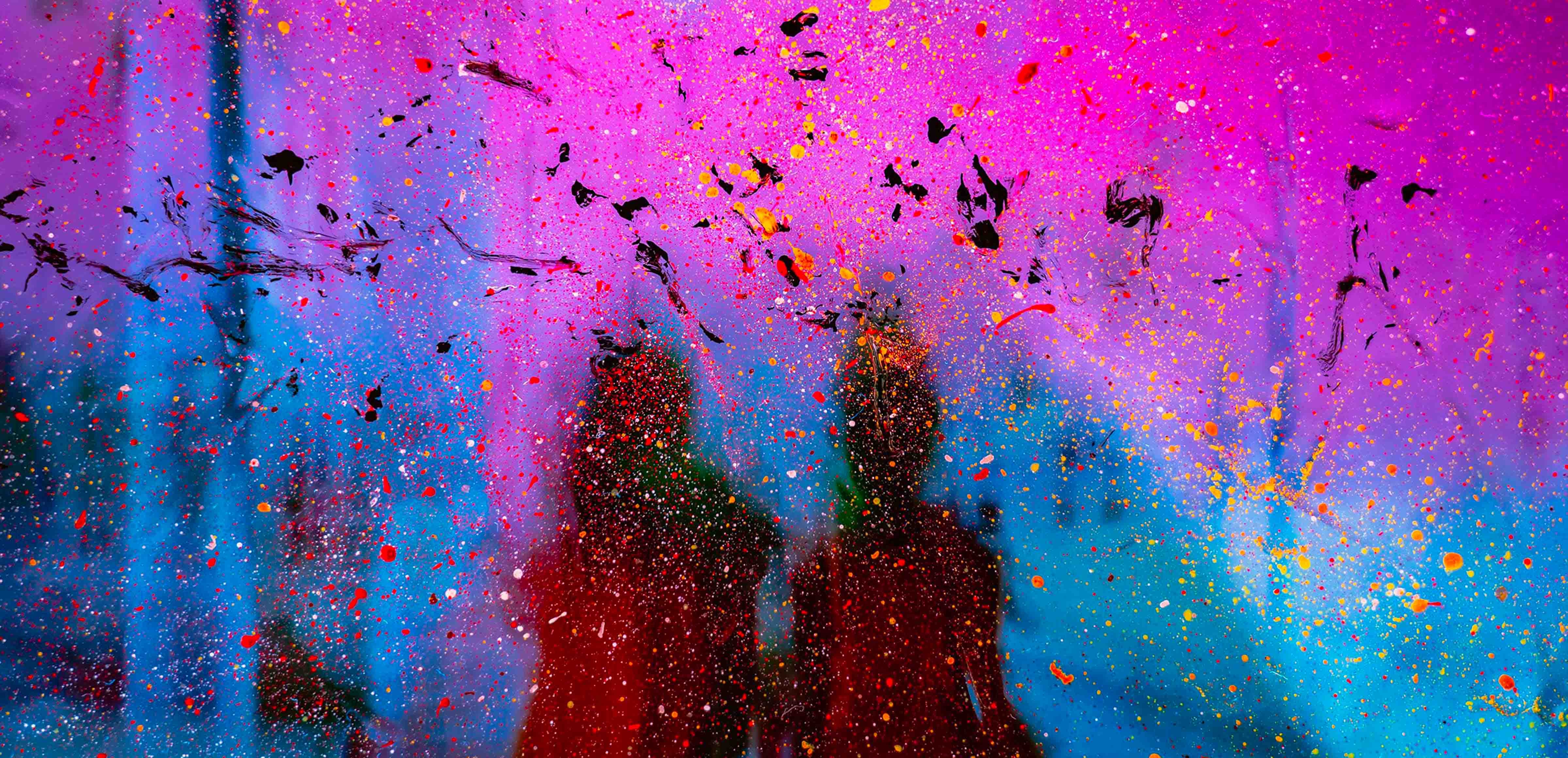 silhouettes of two people behind colored glass